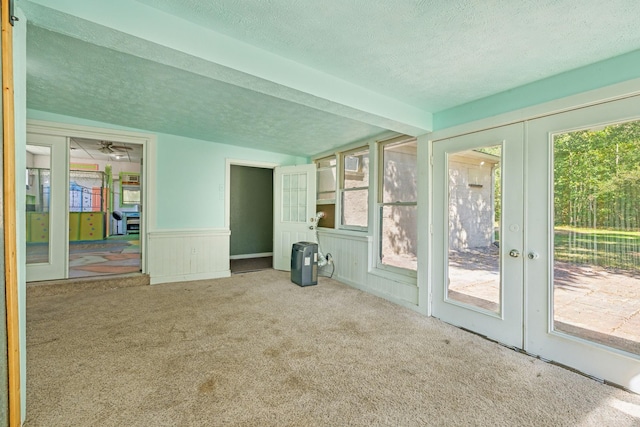 interior space featuring vaulted ceiling, a textured ceiling, and french doors