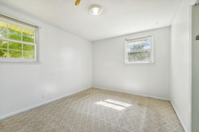 carpeted empty room featuring a textured ceiling