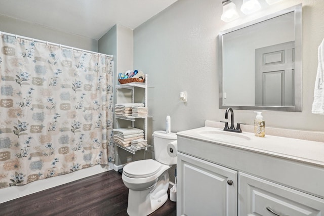 bathroom featuring hardwood / wood-style flooring, vanity, curtained shower, and toilet