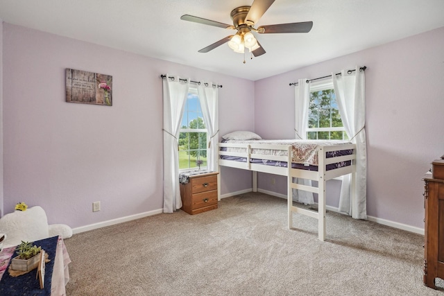 bedroom featuring multiple windows, ceiling fan, and light carpet