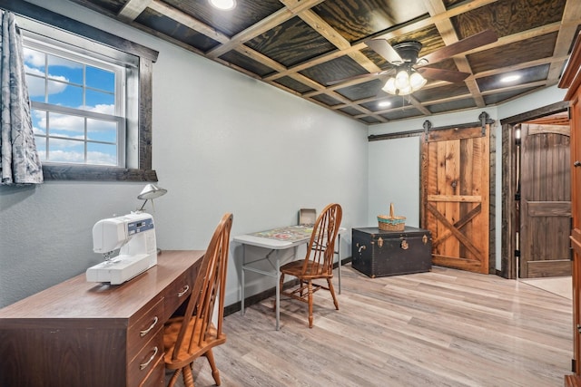 office space with ceiling fan, a barn door, light wood-type flooring, and coffered ceiling