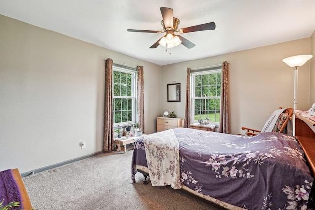 carpeted bedroom with ceiling fan and multiple windows