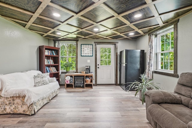 interior space with light hardwood / wood-style floors and coffered ceiling