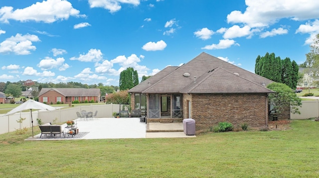 rear view of property featuring a lawn and a patio area