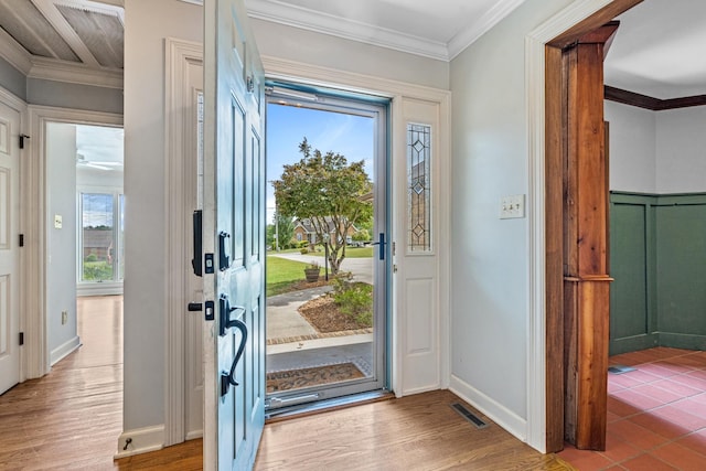 entrance foyer featuring ornamental molding, a healthy amount of sunlight, and hardwood / wood-style floors