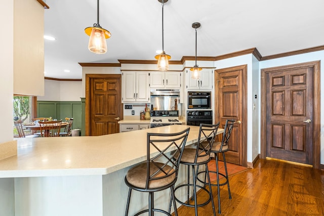 kitchen featuring pendant lighting, white cabinetry, dark wood-type flooring, and ornamental molding