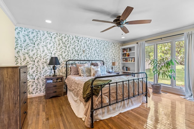 bedroom with hardwood / wood-style floors, ceiling fan, and ornamental molding