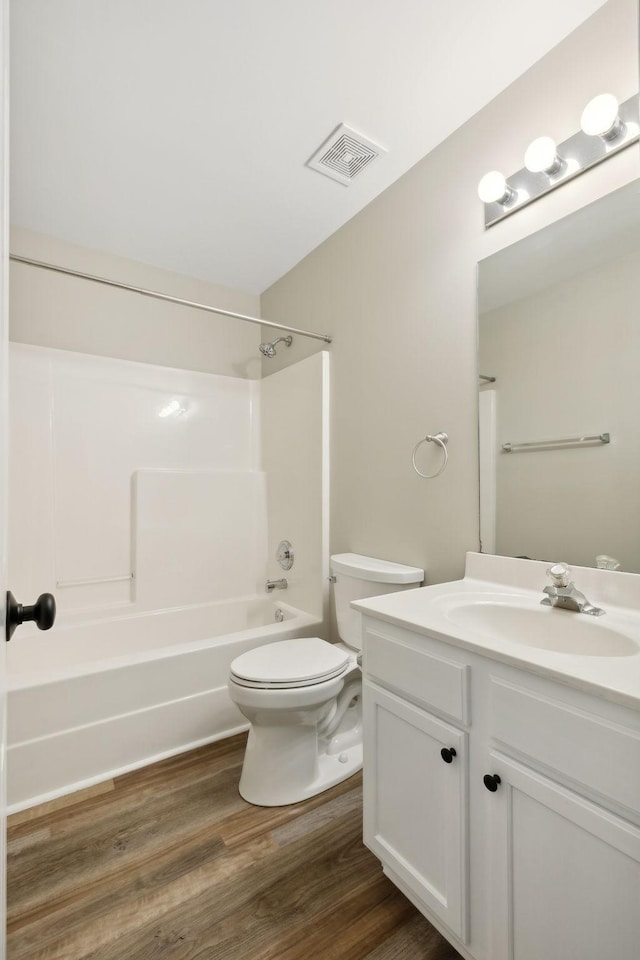 full bathroom with hardwood / wood-style floors, vanity, toilet, and bathing tub / shower combination