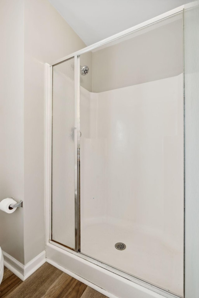 bathroom featuring hardwood / wood-style floors and a shower with shower door