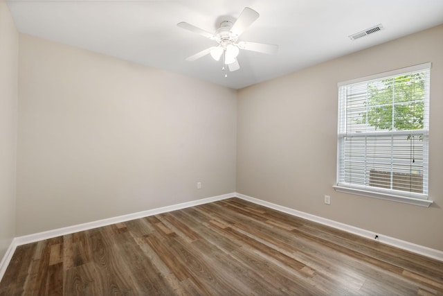 spare room with dark hardwood / wood-style flooring and ceiling fan