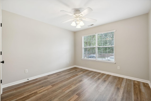 empty room with ceiling fan and dark hardwood / wood-style flooring