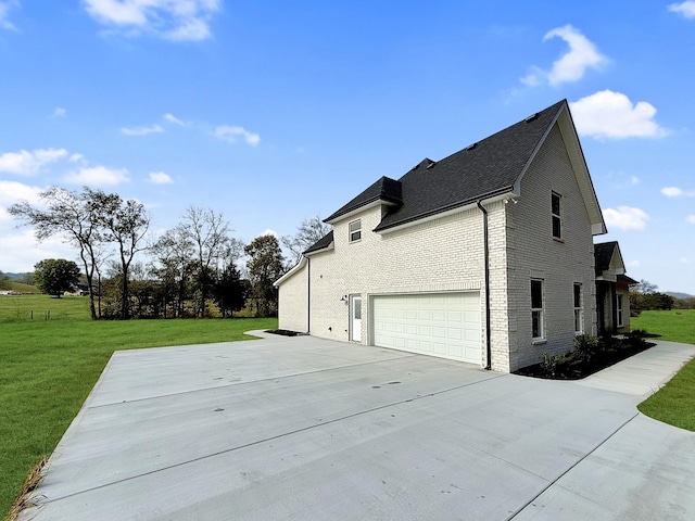 view of side of home with a lawn and a garage