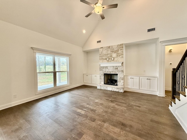 unfurnished living room featuring a fireplace, dark hardwood / wood-style floors, high vaulted ceiling, and ceiling fan