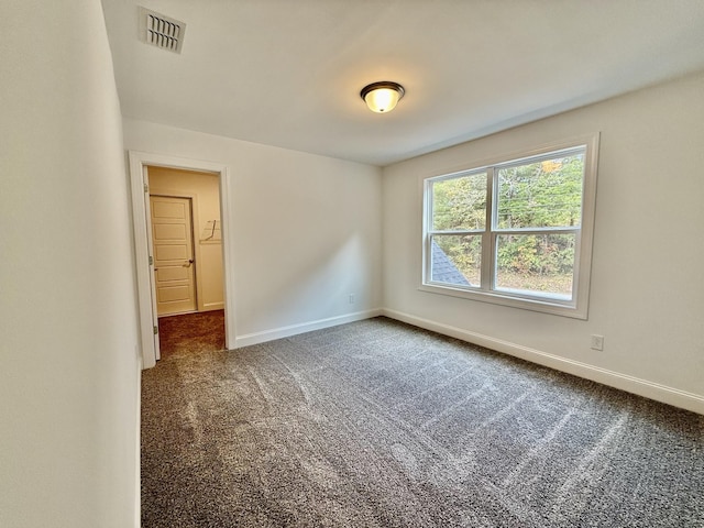 empty room featuring dark colored carpet