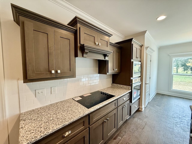 kitchen with dark hardwood / wood-style flooring, stainless steel appliances, light stone counters, and backsplash