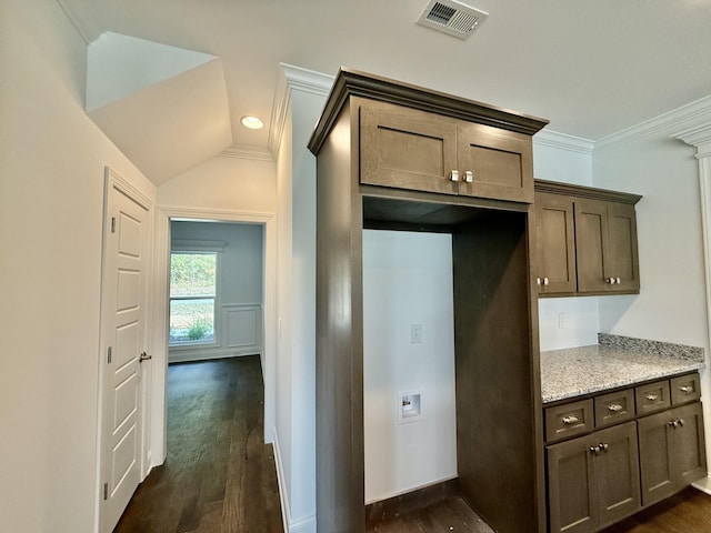 kitchen with dark hardwood / wood-style flooring, light stone counters, dark brown cabinetry, vaulted ceiling, and crown molding