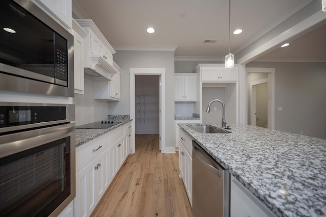 kitchen with white cabinetry, sink, stainless steel appliances, light stone counters, and backsplash