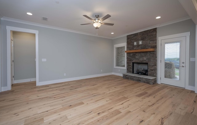 unfurnished living room with light wood-type flooring, a stone fireplace, ceiling fan, and ornamental molding