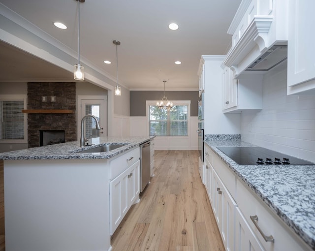 kitchen with sink, hanging light fixtures, a center island with sink, white cabinets, and appliances with stainless steel finishes