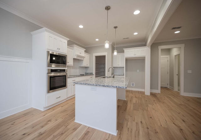 kitchen with light stone counters, white cabinets, and appliances with stainless steel finishes