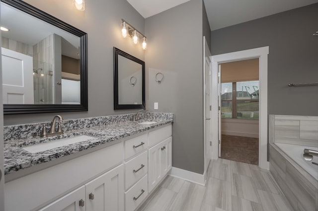 bathroom featuring vanity and a relaxing tiled tub