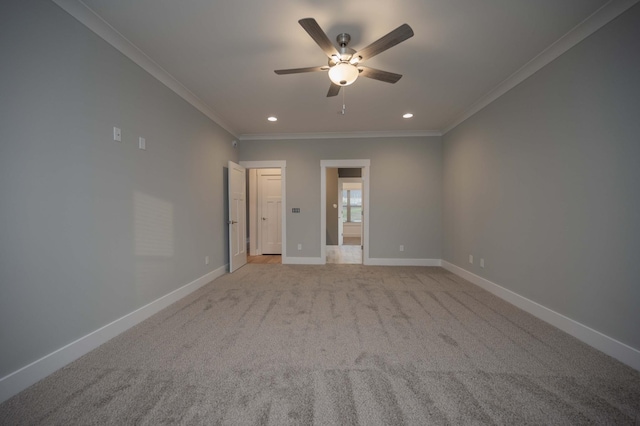 carpeted spare room with ceiling fan and ornamental molding