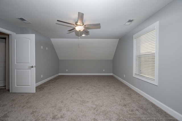 additional living space with ceiling fan, light colored carpet, and vaulted ceiling