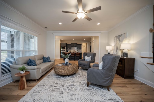 living room featuring hardwood / wood-style floors, ceiling fan, and ornamental molding