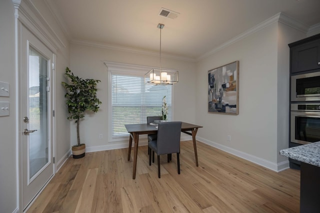 dining area with a notable chandelier, light wood-type flooring, and ornamental molding