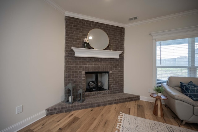 living room featuring a fireplace, ornamental molding, and hardwood / wood-style flooring