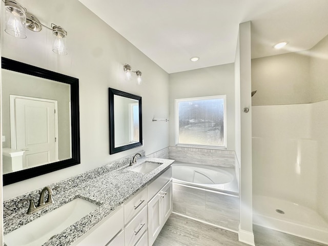 bathroom with separate shower and tub, hardwood / wood-style floors, and vanity