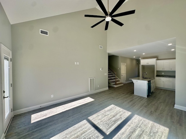 unfurnished living room with ceiling fan, dark hardwood / wood-style flooring, sink, and high vaulted ceiling