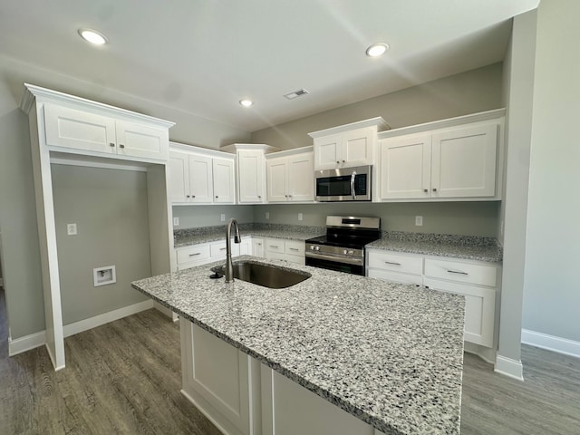 kitchen featuring white cabinets, a center island with sink, sink, and appliances with stainless steel finishes