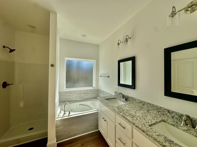 bathroom with hardwood / wood-style flooring, vanity, and separate shower and tub