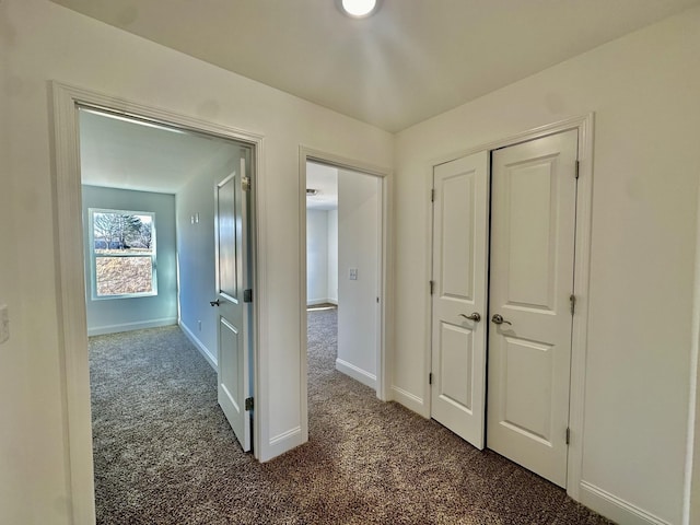 hall featuring dark colored carpet