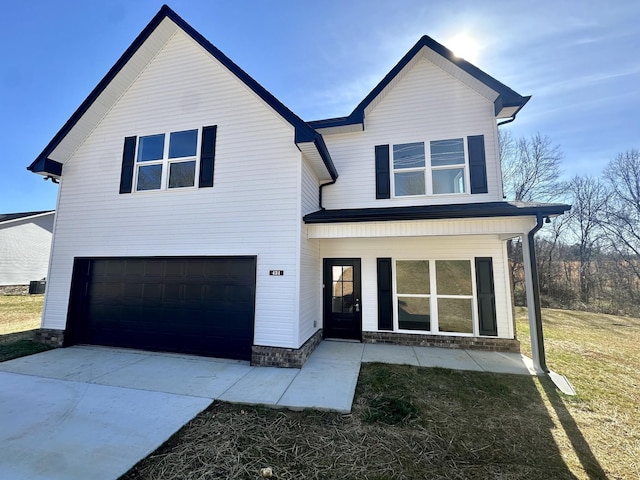 view of front of house with covered porch, a garage, and a front yard