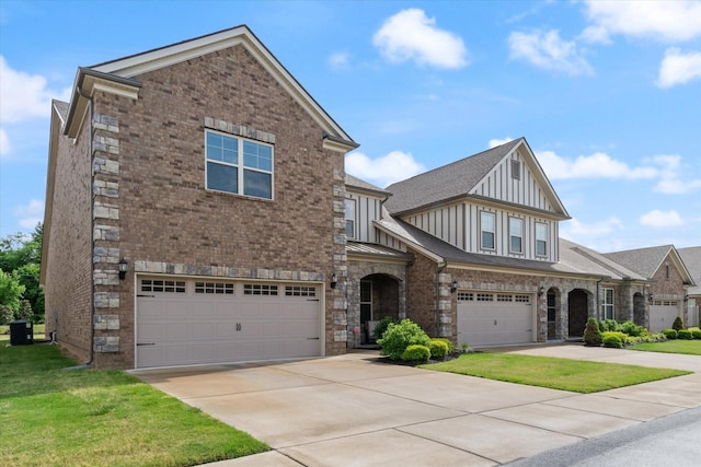 view of front of property featuring a front yard, a garage, and central AC unit