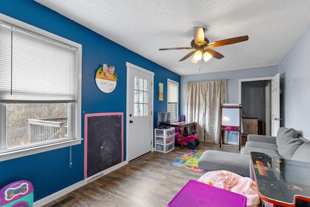 rec room featuring a textured ceiling, hardwood / wood-style flooring, and ceiling fan