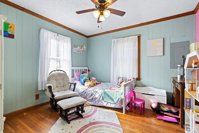 bedroom featuring ceiling fan, light hardwood / wood-style floors, and crown molding