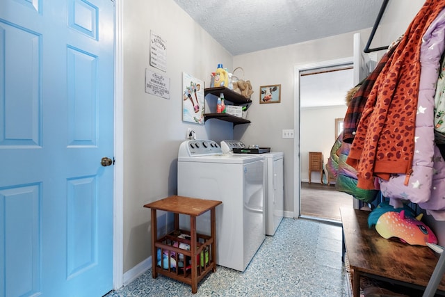 laundry area featuring a textured ceiling and washing machine and dryer