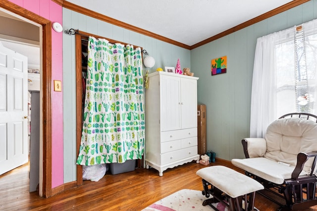 sitting room with hardwood / wood-style flooring and crown molding