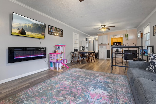 living room with ceiling fan, hardwood / wood-style floors, a textured ceiling, and ornamental molding