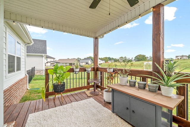 wooden terrace with ceiling fan and a yard