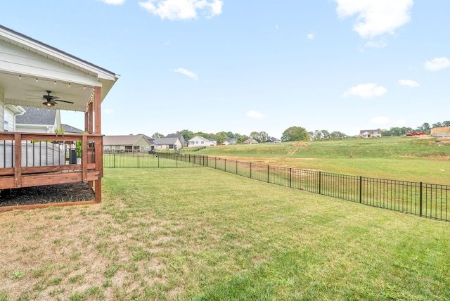 view of yard featuring ceiling fan, a deck, and a rural view