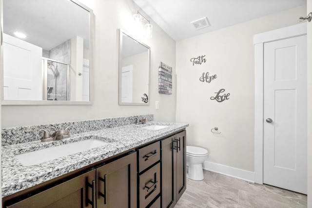 bathroom with a shower with shower door, vanity, and toilet