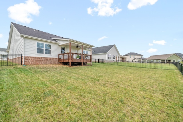 back of property featuring ceiling fan, a lawn, and a deck