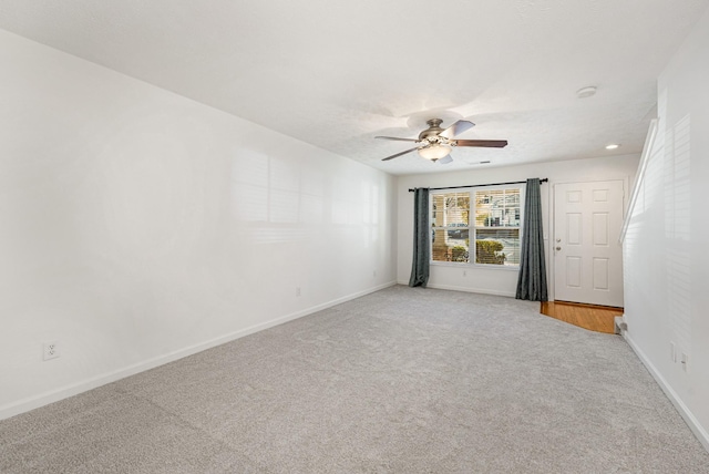 carpeted spare room with ceiling fan