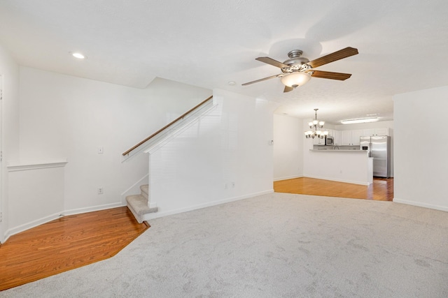 unfurnished living room with ceiling fan and light colored carpet