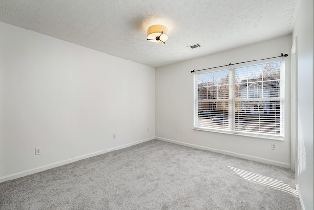 carpeted spare room with a textured ceiling