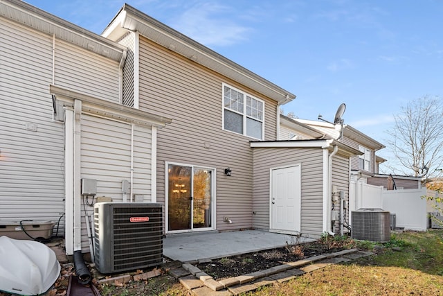 rear view of property with cooling unit and a patio area